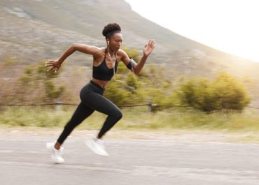 Runner performing warm-up exercises outdoors before a workout