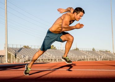 Runner sprinting on a track, focused on running their fastest mile
