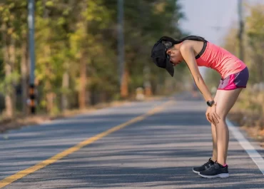 Runner stretching ankles before a run to reduce stiffness